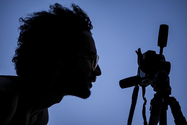 Photographer setting up a tripod at Brooklyn Bridge Park during golden hour, capturing the Manhattan skyline
